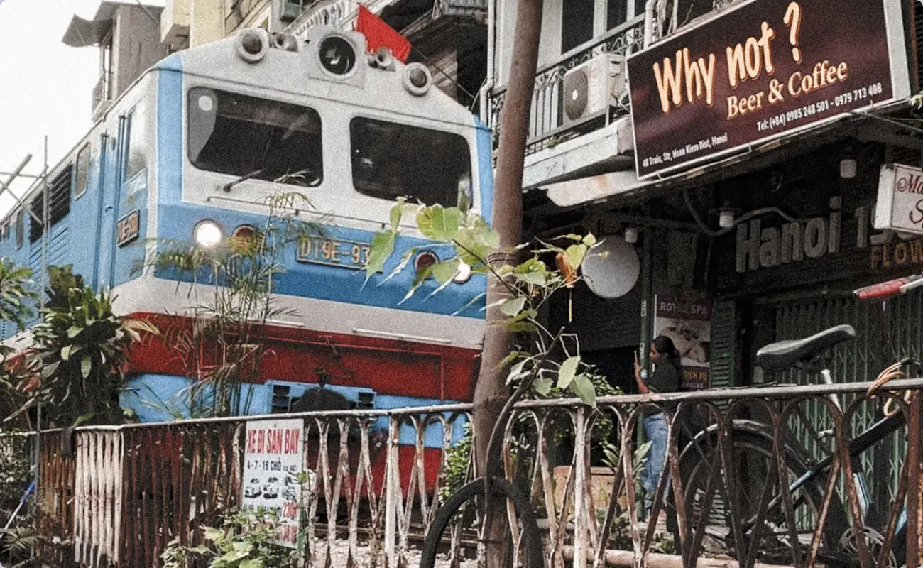 train sreet in hanoi. Ein blau weiß roter zug fährt durch die straße