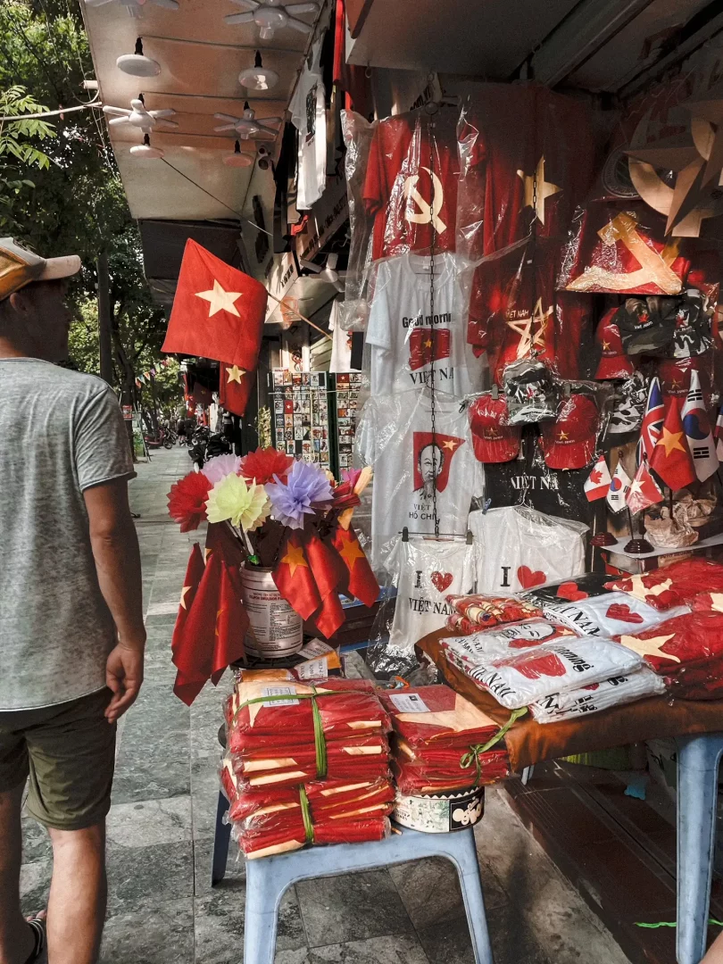 straßenmarkt in hanoi mit einem stand der nationalflaggen in rot und gelb vietnams verkauft